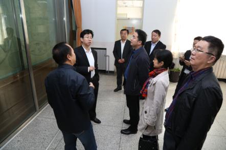 图为银河党委书记郭健与国家文化部领导观赏《坤舆全图》